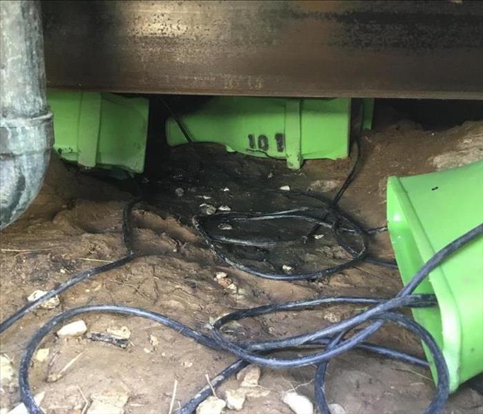 SERVPRO technicians set out dehydration fans to circulate air and dry out the flooded crawl space in this San diego home