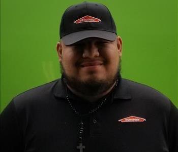 Male production manager SERVPRO technician in front of green wall
